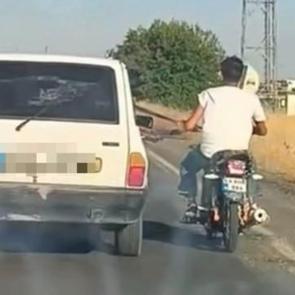 Şanlıurfa'da tehlikeli yolculuk: Motosiklet, otomobil kemerine tutunarak ilerledi