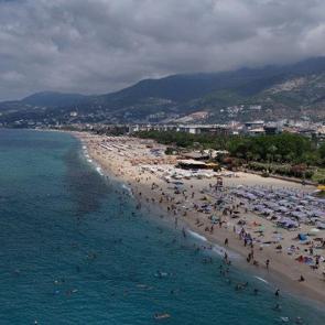 Alanya&rsquo;da hava sıcaklığı arttı, turistler soluğu &uuml;nl&uuml; plajlarda aldı