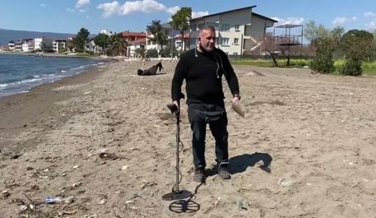 Dedektörle sahilde altın arayan adam görenleri şaşırtıyor!