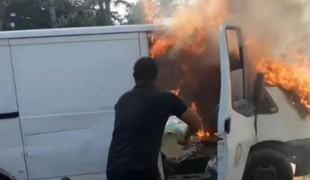 Alev alev yanan aracını kovayla söndürmeye çalıştı
