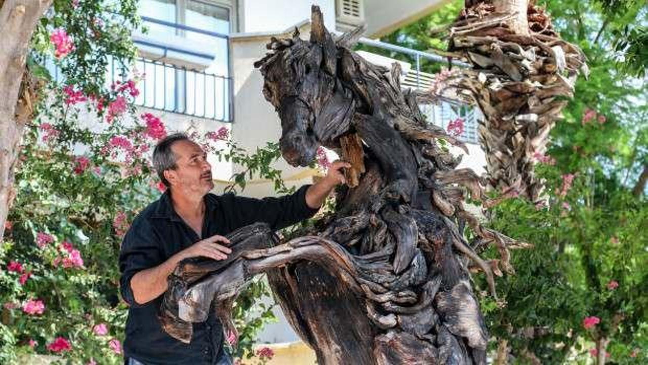 Ünlü sanatçıdan Manavgat'ta yanan ağaç gövdelerinden at figürü
