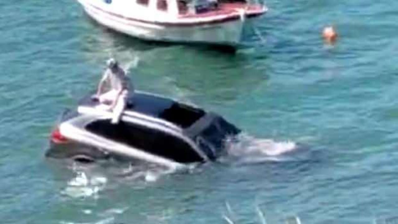 Balıkesir'de ilgin&ccedil; anlar: Denize u&ccedil;an otomobilinin &uuml;zerinde oturup yardım bekledi