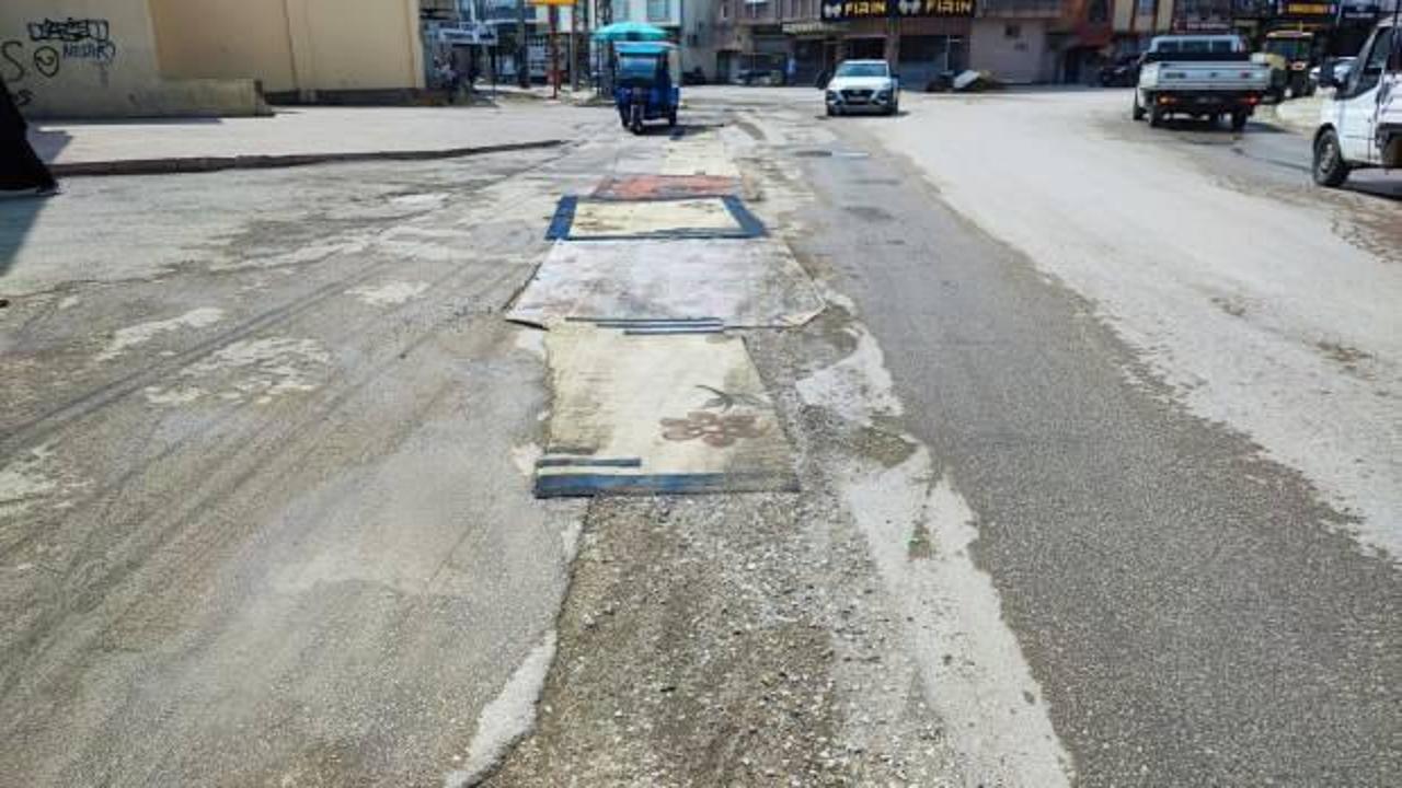 Vatandaşın yol çilesine ilginç çözüm: Sokağa halı serdiler!