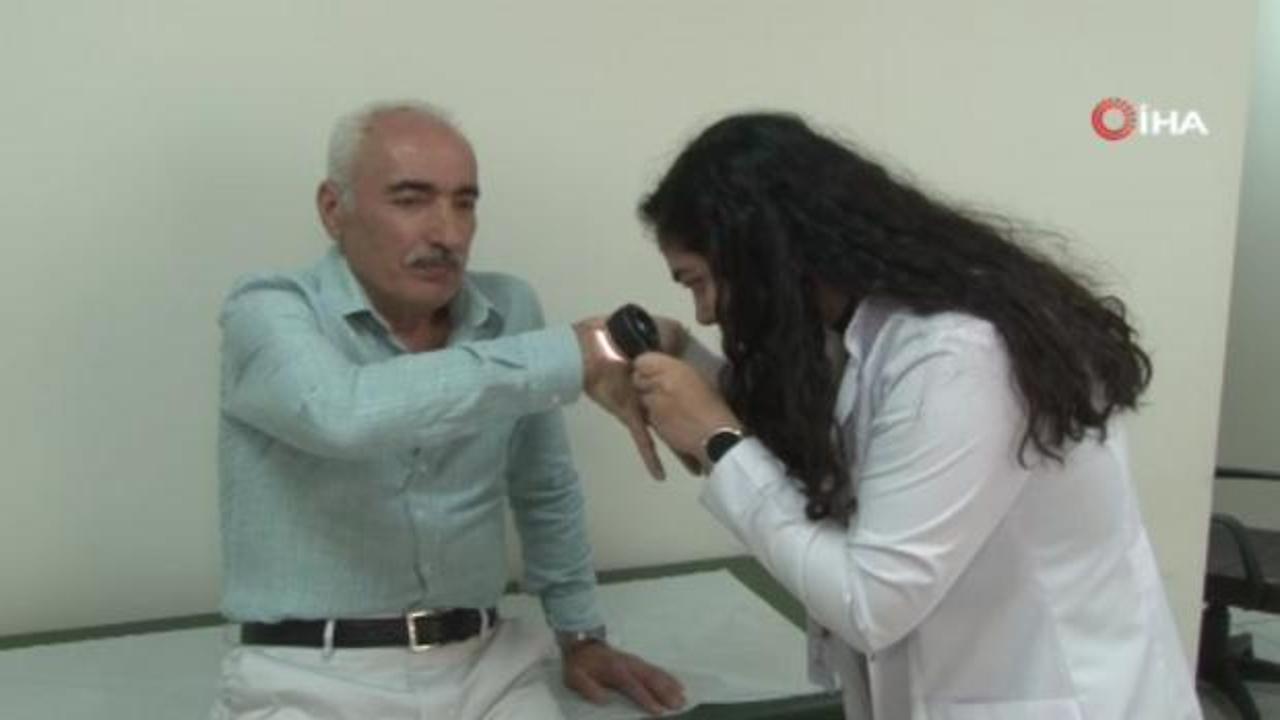 Dirseğinde çıkan küçük bir yaranın cilt kanseri olduğu anlaşılan bir hasta ve onu muayene eden doktor.