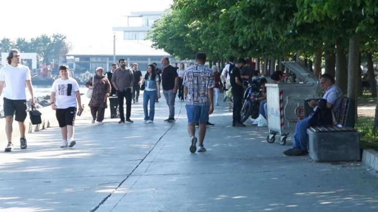 Yaz mevsiminde artan sıcaklıklar ve güneş altında bunalan insanlar.