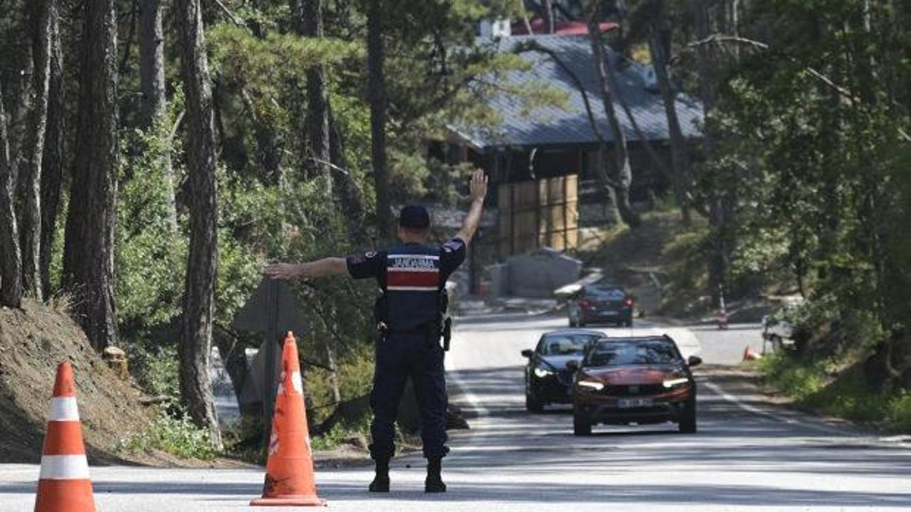 Ormanlık alanda uyarı tabelası ve ağaçlar