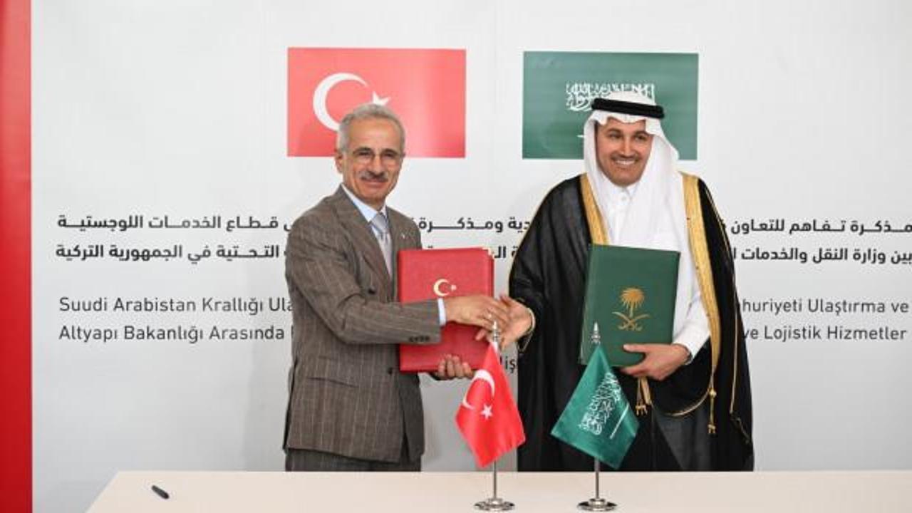 Türkiye ve Suudi Arabistan bayrakları yan yana ve Hicaz Demir Yolu'nu temsil eden bir tren görseli.