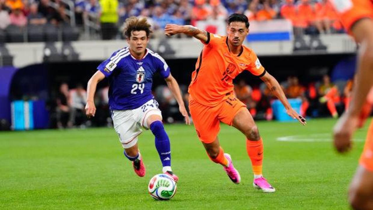 Hollanda ve Japonya milli takımlarının futbolcuları maç sırasında mücadele ediyor.