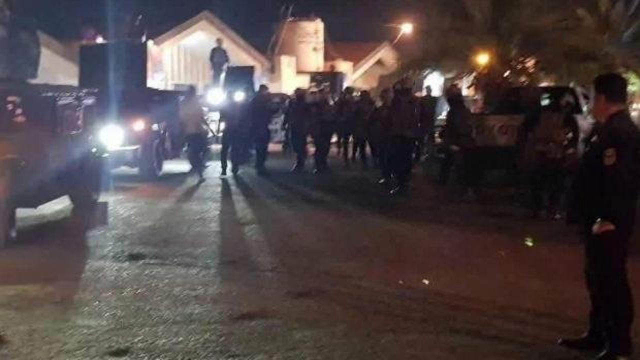 Bağdat'ta yolsuzluk operasyonu kapsamında güvenlik güçlerinin bir binaya girişini gösteren genel plan.