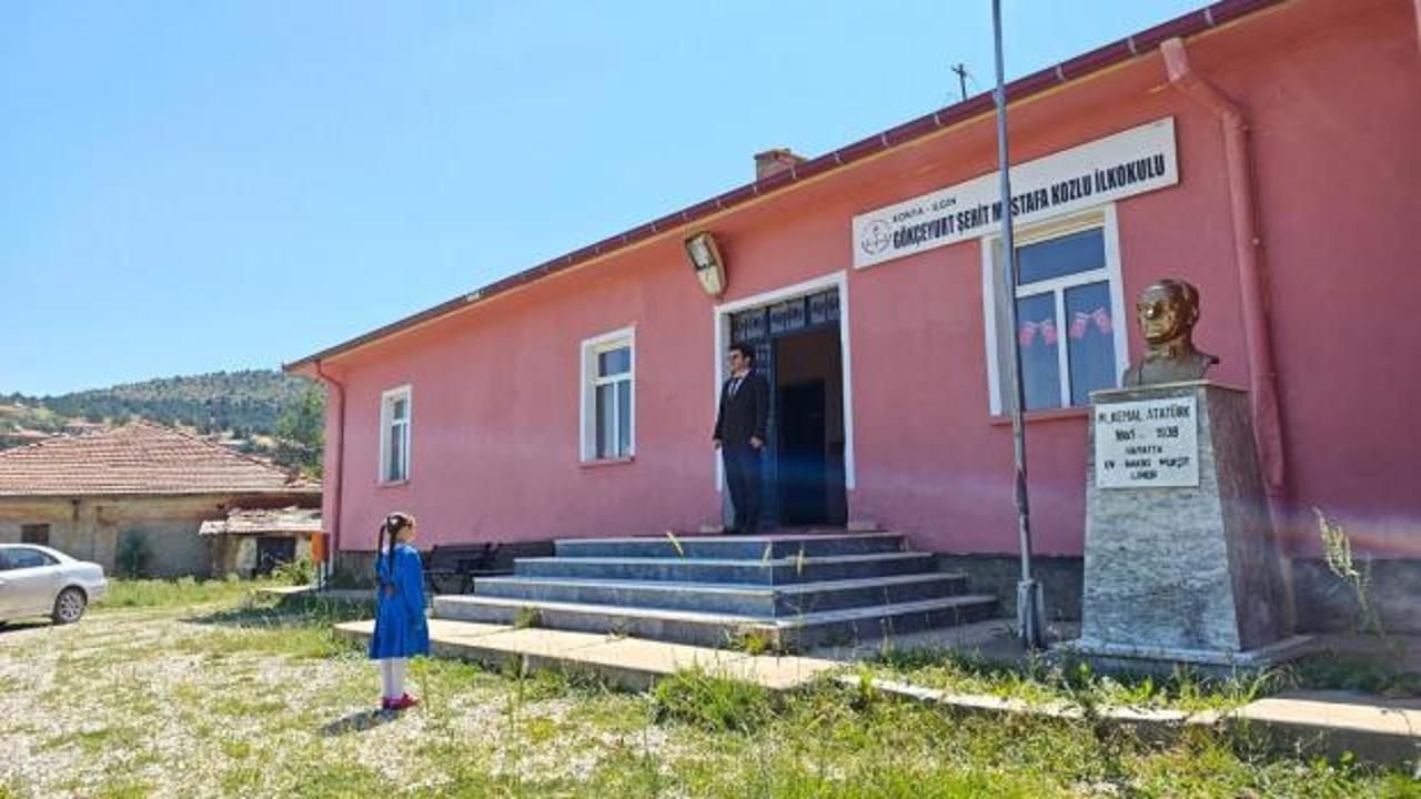 Şehit Mustafa Kozlu İlkokulu'nda tek öğrenci İlayda Kozlu, karnesini öğretmeni Muhammed Bağ'dan alırken