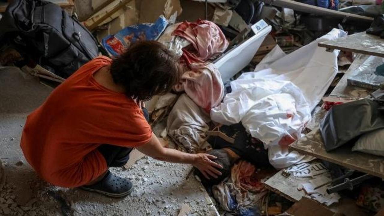 Ukraynalı bir anne, Rusya'nın Kiev saldırısında hayatını kaybeden çocuğunun cansız bedenine dokunuyor.