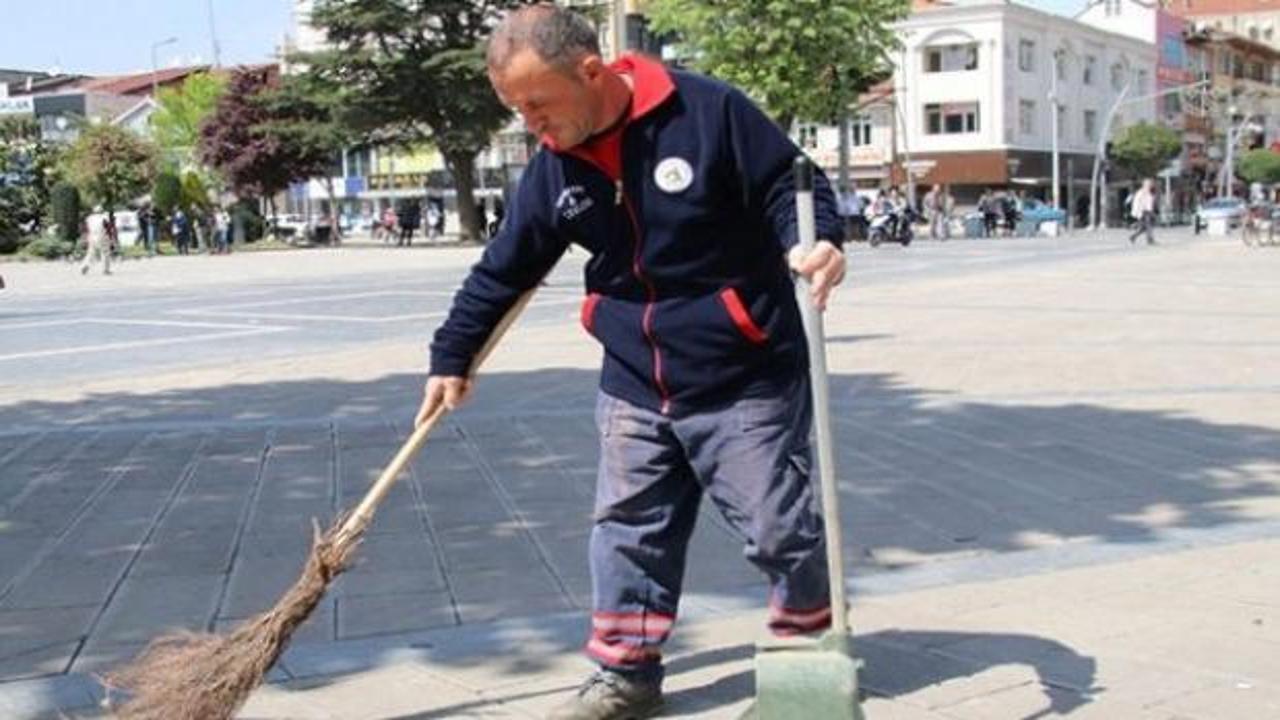 Düzce'de temizlik görevlisi Fatih Cesur, polis merkezinde teslim ettiği altın dolu çantayı gösteriyor.