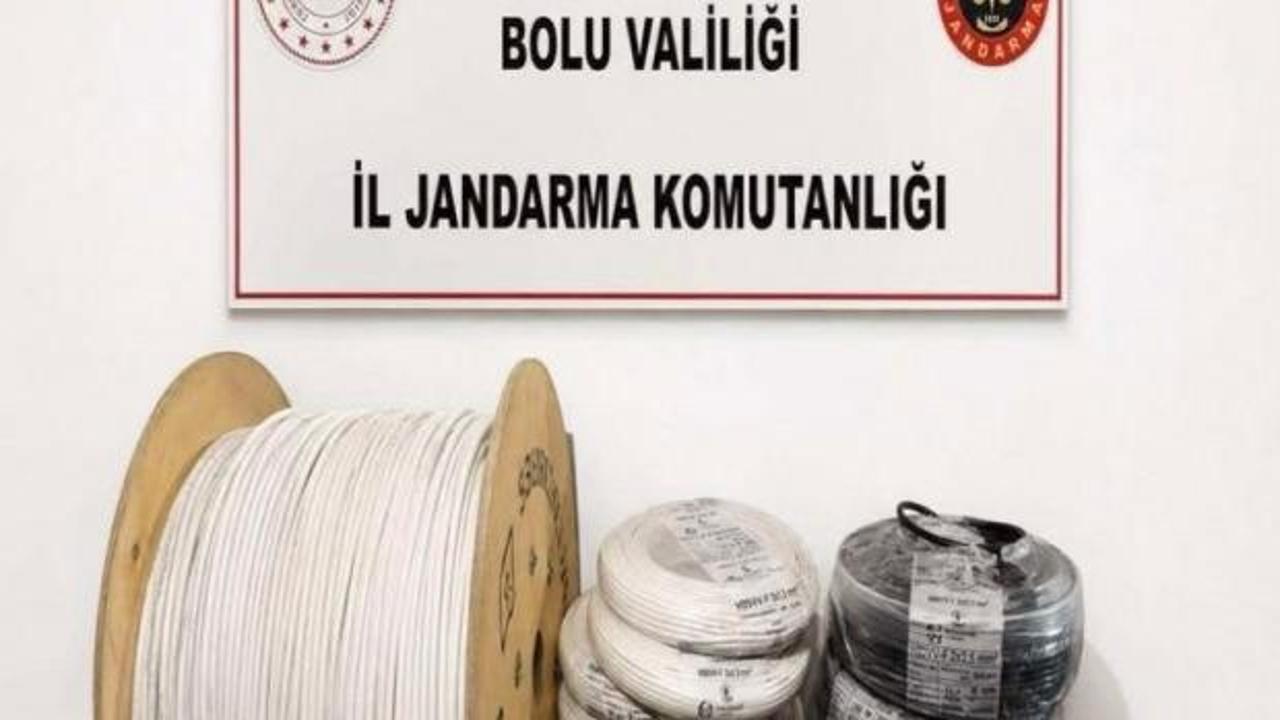 Bolu'da JASAT ekiplerince yakalanan kablo hırsızları ve ele geçirilen çalıntı elektrik kabloları.
