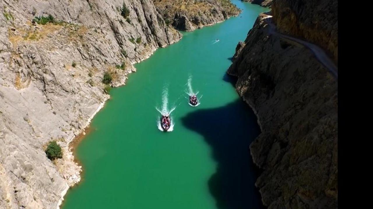 Karanlık Kanyon'da Fırat Nehri'nin serin sularında kano yapan insanlar.