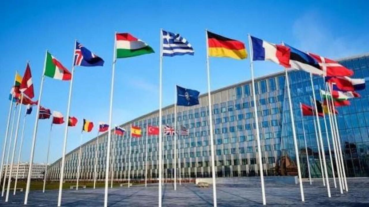 NATO bayrağı ve bir grup ülkenin bayrakları yan yana gösteriliyor, ortak bir finansal kurumun kurulacağını simgeliyor.