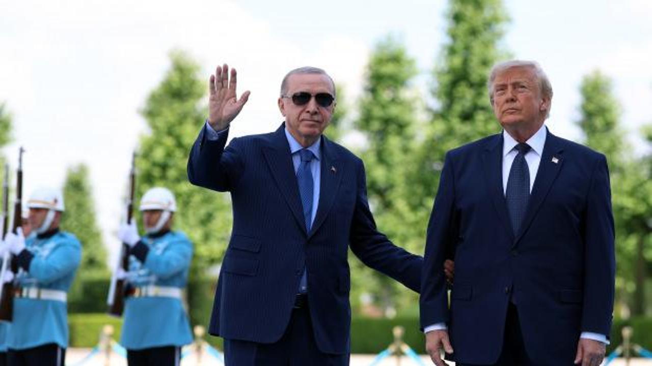 Cumhurbaşkanı Erdoğan ve ABD Başkanı Trump, Ankara'da havalimanı karşılama töreninde samimi bir şekilde sohbet ederken.