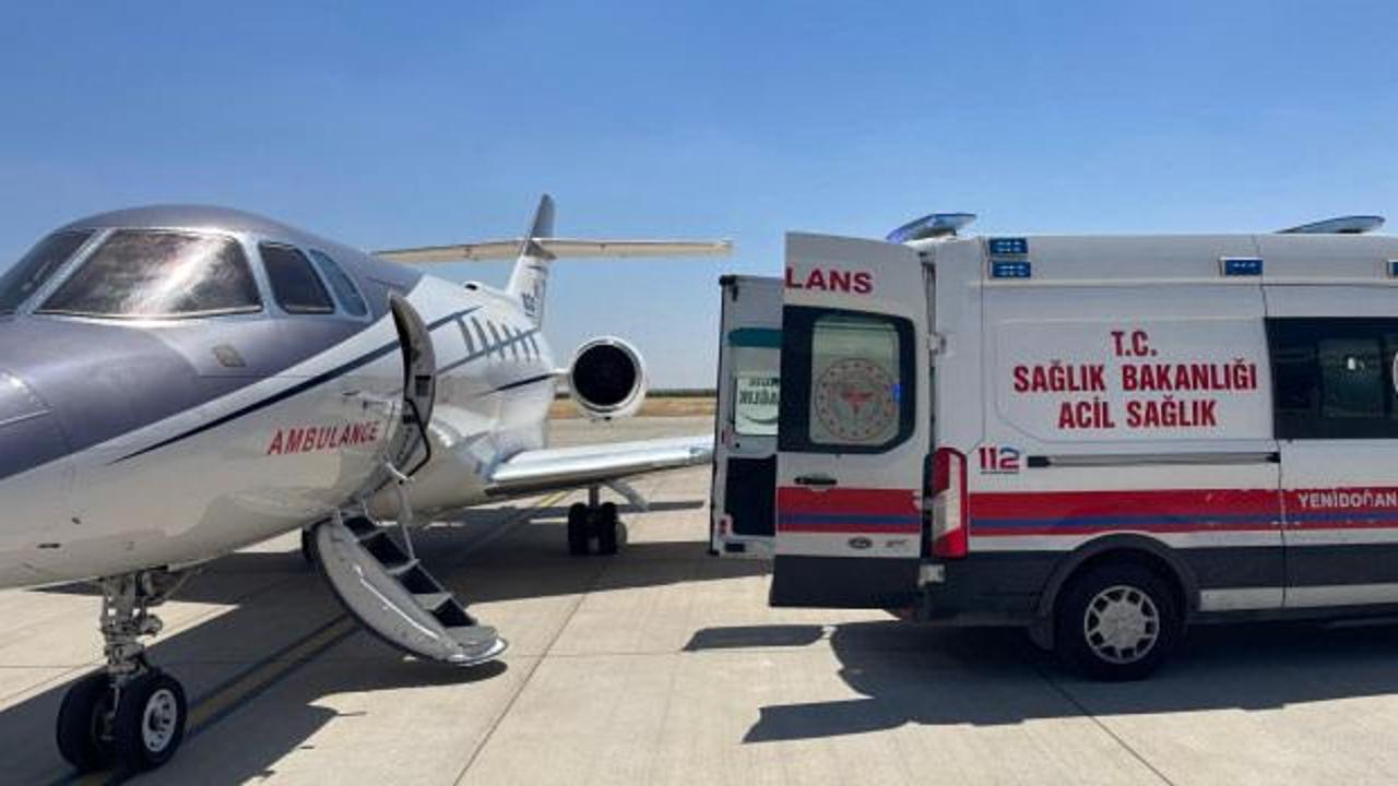 Ambulans uçak pistte bekliyor, sağlık görevlileri bebekle birlikte uçağa yöneliyor.