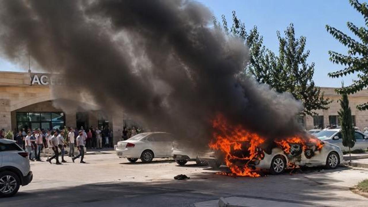 Şanlıurfa Ceylanpınar Devlet Hastanesi açık otoparkında alev alan otomobil.