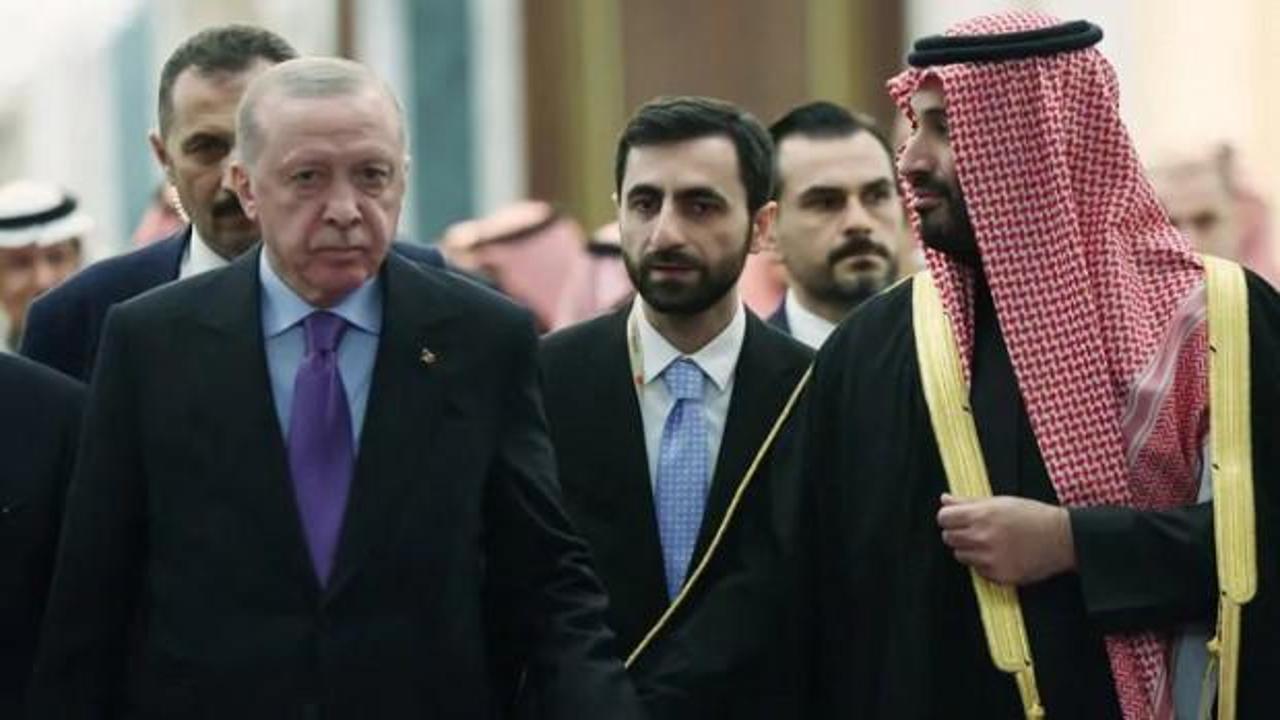 ABD bayrağı ile Suudi Arabistan bayrağının yan yana olduğu, ortasında nükleer sembolü bulunan bir görsel.