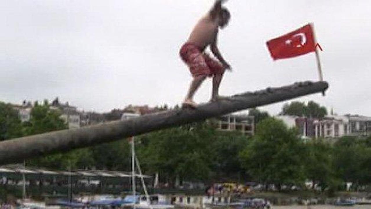 Yağlı direkten bayrağı almak için renkli yarış