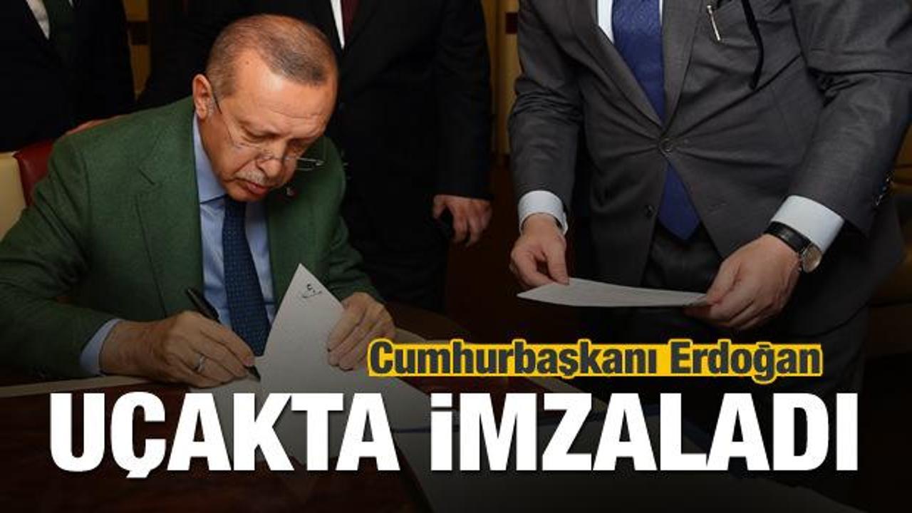 Cumhurbaşkanı Erdoğan uçakta imzaladı