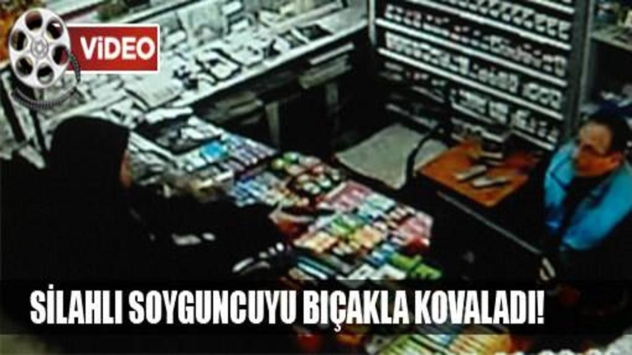 Silahlı soyguncuyu bıçakla kovaladı