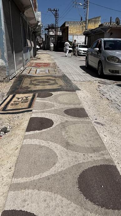 Yol asfaltlanmayınca &ccedil;areyi halı sermekte buldu